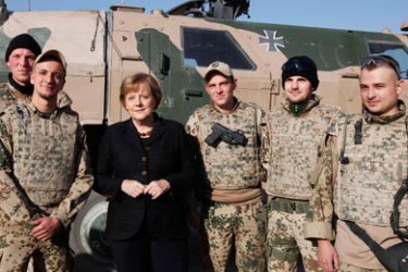 German Chancellor Angela Merkel poses for a group picture with German Bundeswehr armed forces soldiers during a visit to an army camp in Kunduz, northern Afghanistan, December 18, 2010. German Chancellor Angela Merkel is visiting the German Bundeswehr armed forces troops with the International Security Assistance Force (ISAF) in Afghanistan.