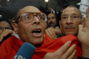 epa02536730 Moncef Marzouki (C), an exiled leader of a secular Tunisian opposition party, waves to supporters upon his arrival in Tunis, Tunisia, 18 January 2011.