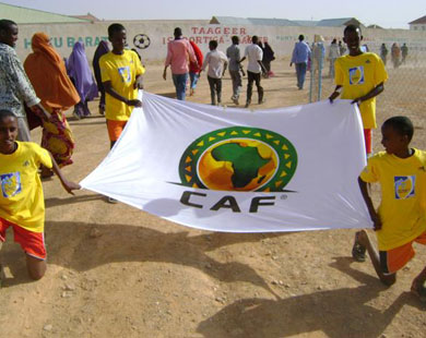 صبية يحملون شعار اتحاد كرة القدم الأفريقية في افتتاح البطولة (الجزيرة نت)