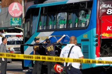 Members of a forensic team examine damage on a passenger bus after an explosion along a major road in Manila January 25, 2011. A bomb exploded on a bus in the Philippine capital on Tuesday killing two people and wounding at least 15 and officials said there was no indication of who was behind it.