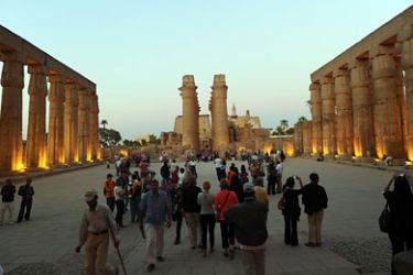 epa- Tourists visiting the Middle Kingdom pharanoic Temple of Luxor pose for a photograph in front of one of the Avenue of the Sphinxes in Luxor, Egypt 06 December 2010.