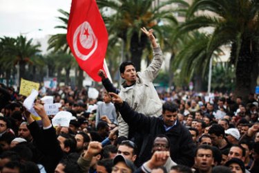 Protesters gestures in front of the headquarters of the Constitutional Democratic Rally (RCD) party of ousted president Zine al-Abidine Ben Ali, during a demonstration in downtown Tunis January 20, 2011