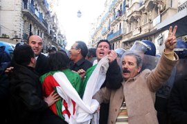 Demonstrators wave flags and shout slogans outside the opposition Rally for Culture and Democracy (RCD) party's headquarters in Algiers on January 22, 2011. Riot police clashed with protesters in the Algerian capital as they broke up a banned pro-democracy rally amid mounting public greivances that have fuelled fears of Tunisia-style unrest.