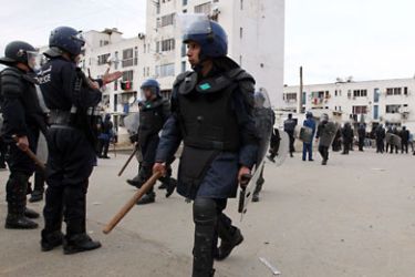 epa02463738 Algerian riot police are seen during clashes in El Anasser suburb of Algiers, Algeria, 23 November 2010. Protesters clashes with riot police by throwing stones and other projectiles in protest against the demolition of their shanty town. EPA