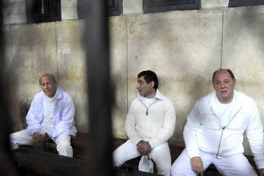 Egypt's former tourism minister Zuheir Garranah (R), former housing minister Ahmed al-Maghrabi (L), and former senior member of the National Democratic Party (NDP) Ahmed Ezz (C) sit behind bars during a hearing in their trial on suspicion of diverting public funds in Cairo on February 23, 2011