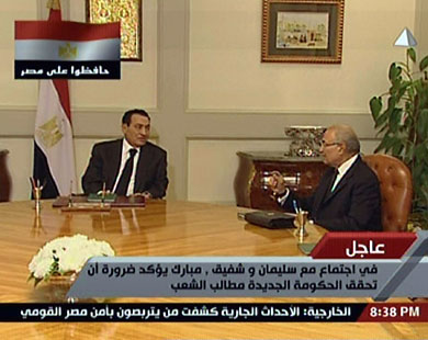 مبارك يتحدث إلى رئيس الحكومة الجديد أحمد شفيق (الفرنسية) 