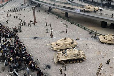 Egyptian anti-government protesters form a security cordon as they face army tanks trying to dismantle their barricades at Cairo's Tahrir square on February 05, 2011, on day 12 of mass protests against
