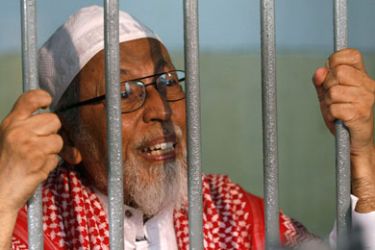 Indonesian cleric Abu Bakar Bashir talks to journalists inside a temporary cell at the South Jakarta court before his trial February 24, 2011. Bashir, spiritual leader of the outlawed Southeast Asian militant group Jemaah Islamiah that is believed to be behind the Bali bombings, faces fresh charges on Monday that carry the death penalty in a trial that refocuses attention on Indonesia's fight against Islamic terror groups.