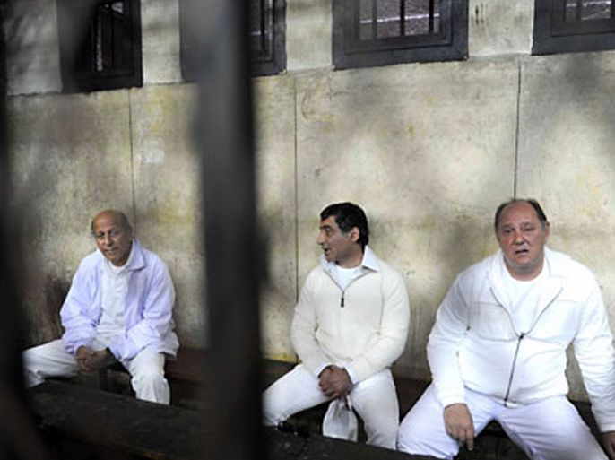 Egypt's former tourism minister Zuheir Garranah (R), former housing minister Ahmed al-Maghrabi (L), and former senior member of the National Democratic Party (NDP) Ahmed Ezz (C) sit behind bars during a hearing in their trial on suspicion of diverting public funds in Cairo on February 23, 2011