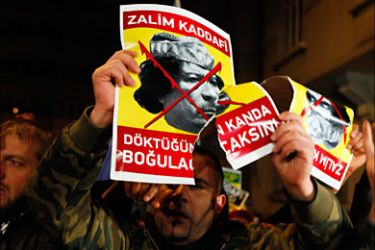 r_A demonstrator holds a torn poster of Libya's leader Muammar Gaddafi during a protest against his regime outside the Libyan consulate in Istanbul, February 21, 2011