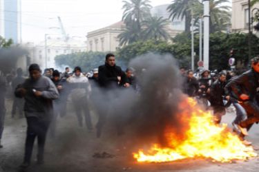Protesters run away during clashes with riot police in downtown Tunis February 26, 2011.