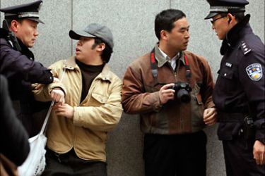 r_Police arrest two men (C) after calls for a "Jasmine Revolution" protest, organised through the internet, in front of the Peace Cinema in downtown Shanghai February 27