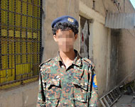 شاب يرتدي بدلة عسكرية استحوذ عليها أثناء نهب مقر الأمن المركزي في أبين أمس الأول (الجزيرة نت)