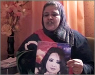 والدة إيمان العبيدي تحمل صورتها بمنزلها في بنغازي أمس (الجزيرة) 