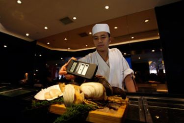 A cook operates a radiation detector over shellfish from Kyushu, Japan, as a Japanese restaurant tries to maintain confidence in the consumption of Japanese food, in Hong Kong March 22, 2011.