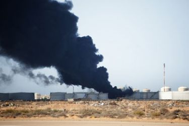 Smoke raises from an oil tank on the outskirt of the eastern oil port town of Ras Lanuf on March 11, 2011 as rebels battled troops loyal to Moamer Kadhafi outside Ras Lanuf a day after the regime recaptured the key oil town.