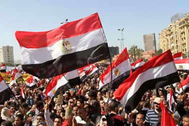 Thousands of Egyptians hold up their national flag as they gather following Friday prayers celebrating the end of former President Hosni Mubarak's regime and the success of their revolution in Cairo's Tahrir Square, on March 4, 2011.