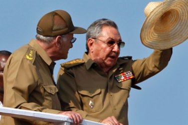 Cuba's president Raul Castro (R) waves to the crowd next to Interior Minister Abelardo Colome during a military parade in Havana April 16, 2011.