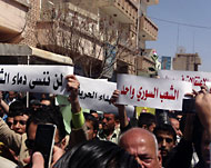 متظاهرون بالقامشلي يرفعون شعارات في مظاهرة بشمال سوريا (رويترز)