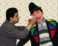 الفنان محسن خضير وهو يرسم إحدى الدمى (الجزيرة نت)