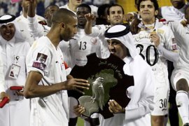 Lekhwiya's Moroccan defender Abdeslam Ouaddou (L) receives the trophy from Sheikh Hamad bin Khalifa bin Ahmed al-Thani, president of Qatar's Football Federation