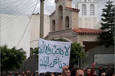 A picture taken by a mobile phone shows Syrian anti-government protesters holding a banner "No Baath party, no Assad. We want to liberate the country" during a demonstration in Banias in northeastern Syria on