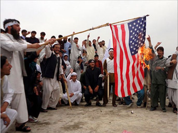 R: Afghans burn a U.S. flag during a protest in Khost province April 9, 2011. The Afghans protested against the burning of a Koran supervised by Florida-based radical fundamentalist Christian preacher Terry Jones. REUTERS/Stringer
