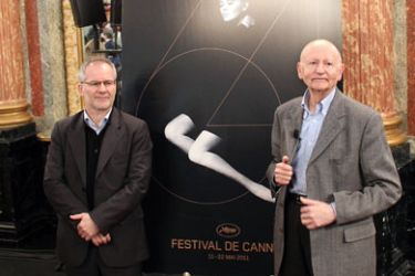 The president of the Cannes Film Festival Gilles Jacob (R) and the general delegate of the Cannes Festival, Thierry Fremaux stand in front of the festival official poster during a press conference to present the films competing in the next 2011 Cannes Film Festival, on April 14, 2011 in Paris