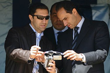FILES)--A March 29, 2006 file photo of Egyptian President Hosni Mubarak's sons Gamal (R) and Alaa (L) try their video camera as they wait for the fourth total solar eclipse of the 21st century in Sallum, on the border with Libya in northwestern Egypt. The sons