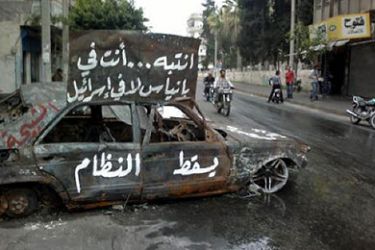 A picture taken by a mobile phone shows a burnt car with the slogan "Attention, you are in Banias, not Israel. Down with the regime" in Banias in northeastern Syria on April 17, 2011. A pledge by Syria's embattled president to lift almost 50 years of draconian emergency rule within a week was brushed aside as not enough, as activists called for more protests.