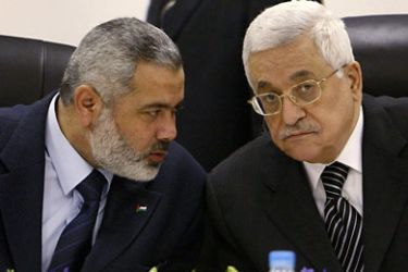 r_Palestinian President Mahmoud Abbas (R) listens to Hamas leader Ismail Haniyeh during the first cabinet meeting of the Palestinian unity government in Gaza in this March 18, 2007