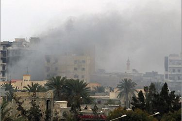 A building near Tripoli street is burning following heavy fighting in Misrata April 21, 2011. Libyan government troops pounded the besieged rebel-held city of Misrata, undeterred by Western threats to step up military action against Muammar Gaddafi's forces.
