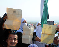 نساء يحملن شهادات ملكيتهن أراض بفلسطين  