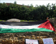 طفل عربي بجانب العلم الفلسطيني يحتج على مخطط تهجير العرب من اللد (الجزيرة نت)