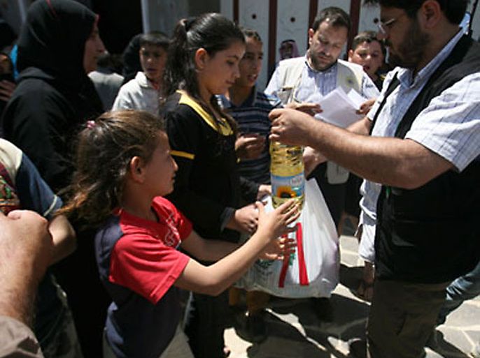 Syrian refugees receive food and humanitarian aid from a Turkish relief agency at the northern Lebanese village of Wadi Khaled near the Lebanese-Syrian border, May 21, 2011. Syrians who fled for their lives from a security crackdown in the border town of Tel Kelakh say violence has hardened attitudes towards Syria's President Bashar al-Assad and unrest will not end until he steps down.