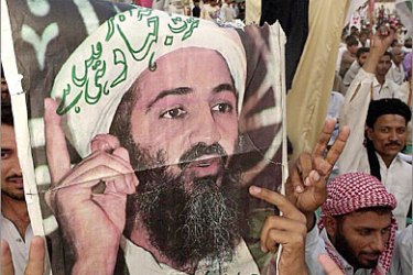 AFP(FILES) An activist of ethnic Mohajir Quami Movement (MQM) carries a portrait of wanted terrorist Osama bin Laden while an activist shouts anti-US slogans during a demonstration in Karachi on October 7, 2001. A Pakistani