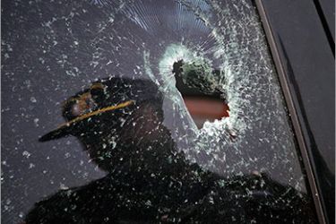 A policeman is reflected in a window of a car shattered by bullets, currently parked in a police station, in which a Saudi diplomat was travelling in when under attack by gunmen, in Karachi May 16, 2011. Gunmen on motorcycles attacked the car belonging to the Saudi Arabian consulate in the Pakistani city of Karachi on Monday killing a Saudi diplomat, police and the Saudi ambassador