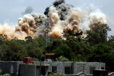 Smoke billows behind the trees following an air raid on the area of Tajura, 30 km east of Tripoli, as loud explosions rocked the Libyan capital on May 24, 2011 when NATO unleashed its heaviest blitz yet of the area in a bid to speed up the ouster of Libyan leader Moamer Kadhafi.