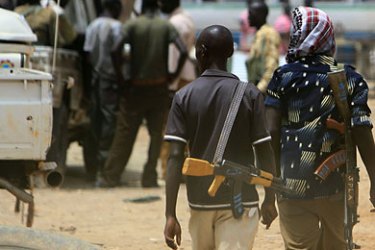 (FILES) Armed men walk on April 17, 2011 in the restive town of Abyei, on the Sudanese north-south border. Sudan’s flashpoint border town of Abyei is burning, with gunmen looting properties after its capture by Khartoum troops, UN peacekeepers said on May 23, 2011.
