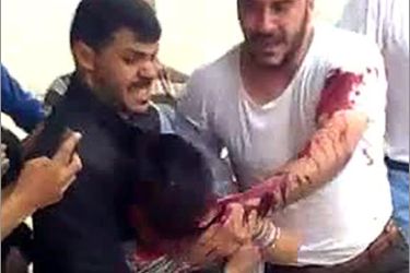 An image grab taken on May 23 from a video posted on YouTube on May 20, 2011 shows Syrian men carrying a wounded boy, who later died of his injuries, during an anti-regime protest in the central