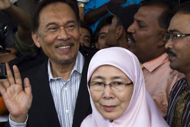 epa02735785 Malaysian opposition leader Anwar Ibrahim (L) and wife Wan Azizah leave the courthouse in Kuala Lumpur, Malaysia, 16 May 2011.