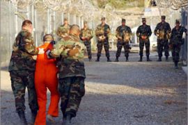 REUTERS/ U.S. Army Military Police escort a detainee to his cell during in-processing to the temporary detention facility at Camp X-Ray in Naval Base Guantanamo Bay in this file photograph taken January 11, 2002 and released January 18, 2002. Al Qaeda leader Osama bin Laden was killed in a firefight with U.S. forces in Pakistan on May 1, 2011, ending a nearly 10-year worldwide hunt for the mastermind of the Sept. 11
