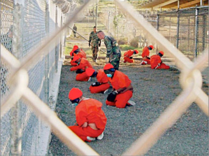 REUTERS/ Detainees sit in a holding area during their processing into the temporary detention facility, as they are watched by military police, at Camp X-Ray inside Naval Base Guantanamo Bay in this January 11, 2002 file photograph. Al Qaeda leader Osama bin Laden was killed in a firefight with U.S. forces in Pakistan on May 1, 2011, ending a nearly 10-