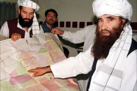 Jalaluddin Haqqani (R), the Taliban's Minister for Tribal Affairs, points to a map of Afghanistan while his son Naziruddin (L) looks on, during a visit to Islamabad, Pakistan, in this October 19, 2001 file photo. To match to Special Report - BINLADEN/PAKISTAN-ISI. Picture taken October 19, 2001.