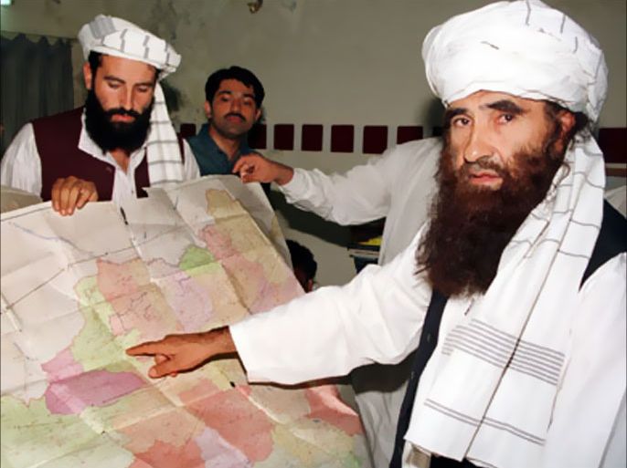 Jalaluddin Haqqani (R), the Taliban's Minister for Tribal Affairs, points to a map of Afghanistan while his son Naziruddin (L) looks on, during a visit to Islamabad, Pakistan, in this October 19, 2001 file photo. To match to Special Report - BINLADEN/PAKISTAN-ISI. Picture taken October 19, 2001.