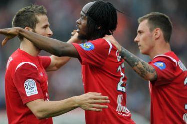 Lille's foward Gervinho (C) is congratuled by Lille's Poland midfielder Ludovic Obraniak and Lille's french midfielder Mathieu Debuchy (L) after scoring a goal during the French L1 football match Lille vs. Arles Avignon on April 30,2011 at Lille metropole stadium in Villeneuve-d'Ascq.