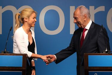 JER4386 - JERUSALEM, -, - : Israel's President Shimon Peres (R) and Colombian singer and UNICEF global goodwill ambassador Shakira shake hands following a joint press conference in Jerusalem on June 21, 2011. Shakira is in Jerusalem to attend the Israeli Presidential Conference with President Shimon Peres. AFP PHOTO/GALI TIBBON