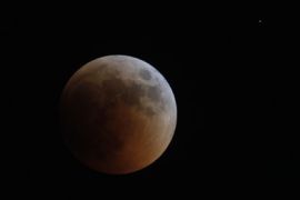 A shadow falls on the moon during a lunar eclipse as seen from Amman June 15, 2011.