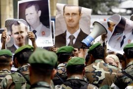 Lebanese army soldiers prevent pro-Syrian regime demonstrators holding up images of President Bashar al-Assad from reaching the Lebanese Sunni Islamist al-Tahiri party members as they perform Friday noon prayers in the nearby al-Omary mosque in downtown Beirut on June 3, 2011.