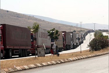 Turkish trucks wait on June 25, 2011 at the southern Turkish border crossing of Cilvegozu to enter Syria. Turkish truck drivers say Syrian authorities and part of the population are being hostile toward them since Turkey opened its border to Syrian refugees escaping the unrest in their country. Almost 12,000 Syrian refugees are